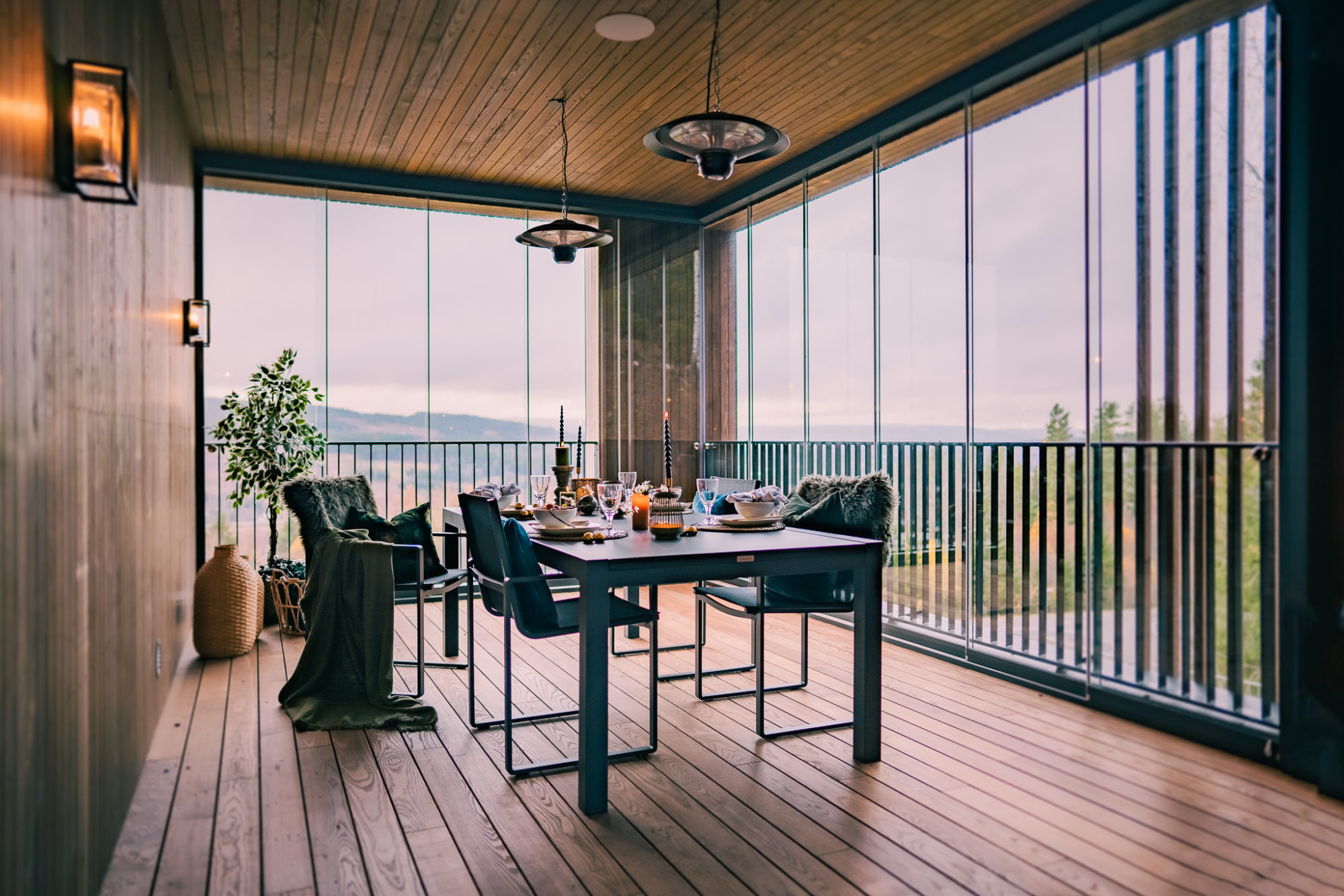 uteDESIGN_JohannesTB_2048px-01 – Kopi En vakker pergola på en utendørs uteplass på en husbalkong, med glassvegger, et paneltak i tre, utemøbler og et bord, bygget av uteDESIGN