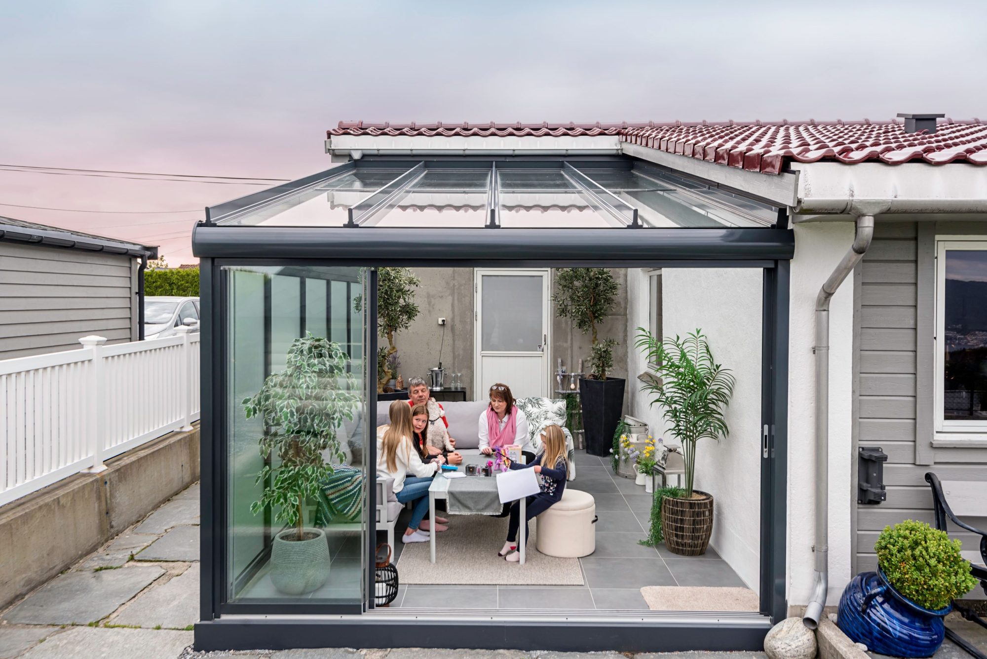 Utestue eller pergola – 4 Bildet av en famile som nyter en kveld i løsningen deres.