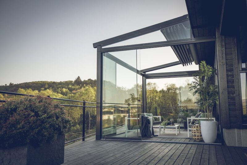 Bildet av en pergola med glassvegger. Taket er skrått og foldet sammen på toppen.