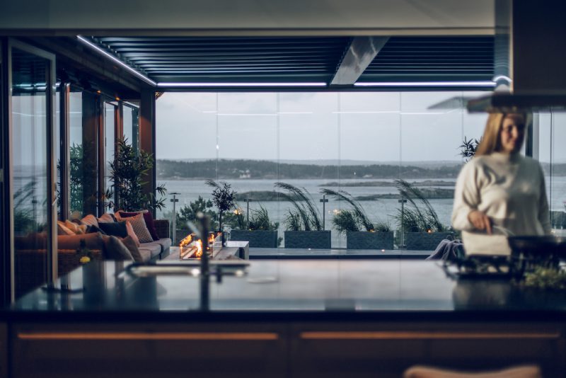 Bildet av en pergola med duk, på kveldstid med sjøutsikt.