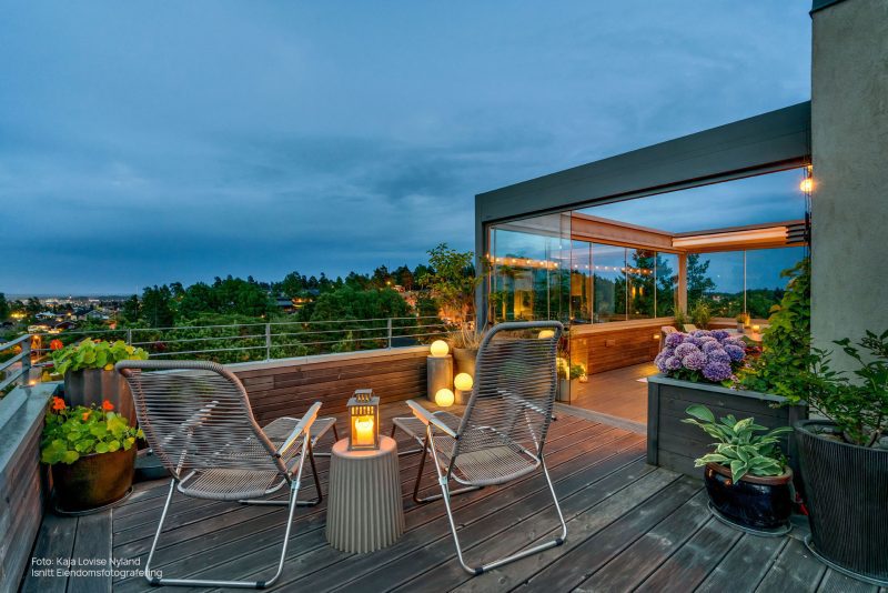 Bildet av en pergola på terrasse med planter og utemøbler.